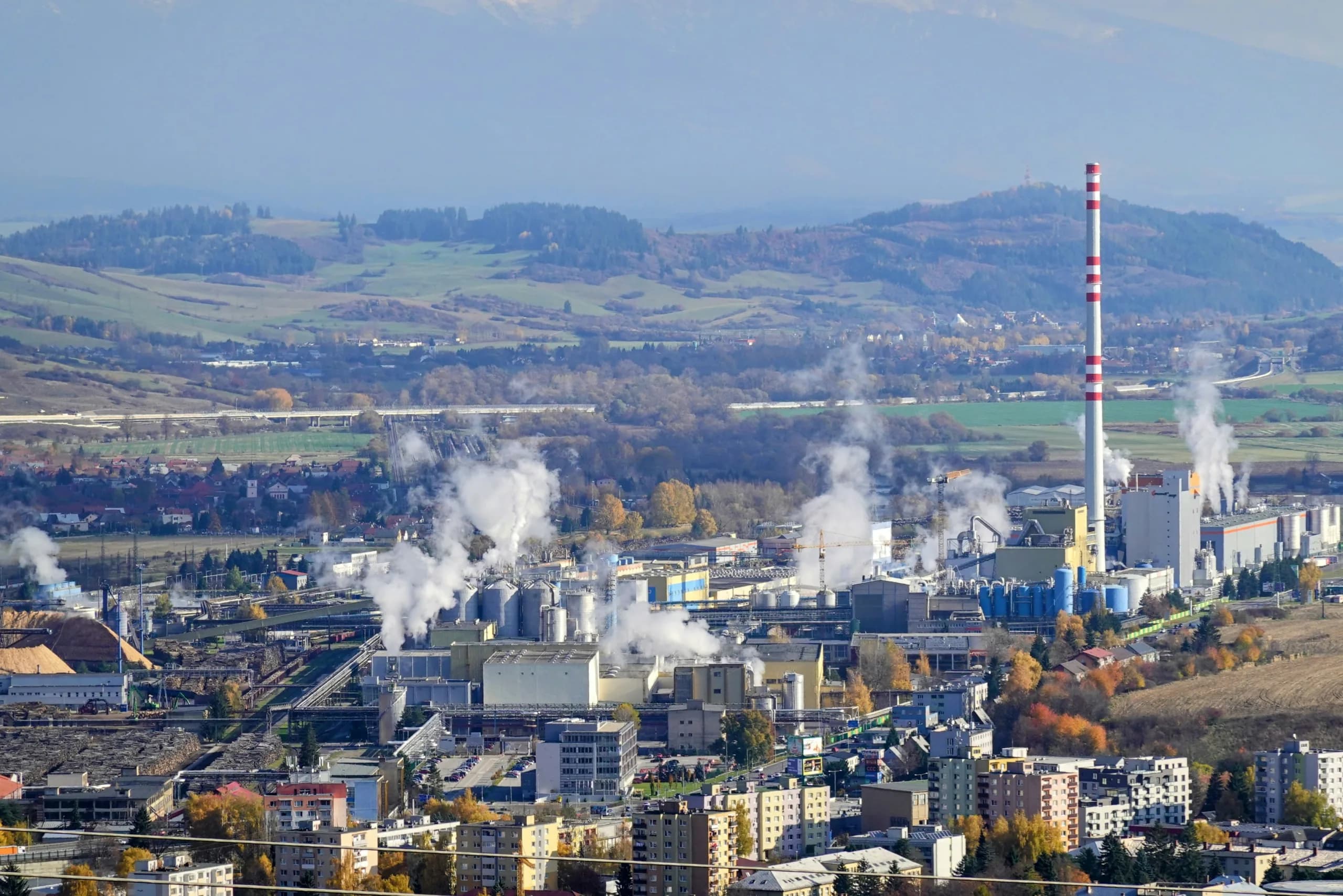 District heating plant with steam plumes in a valley