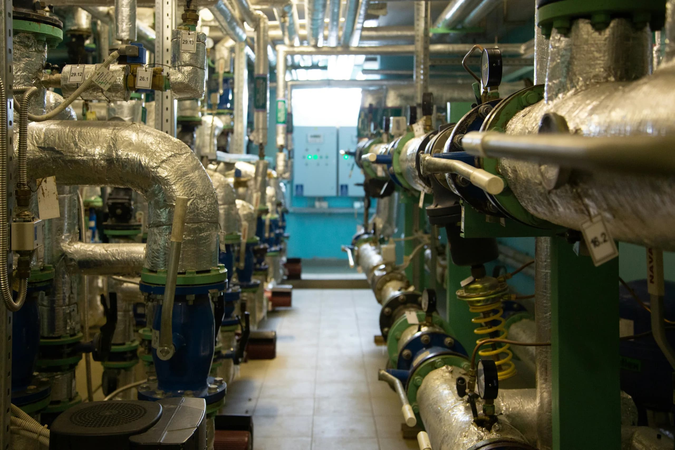 Insulated pipework and pumps inside a heat plant